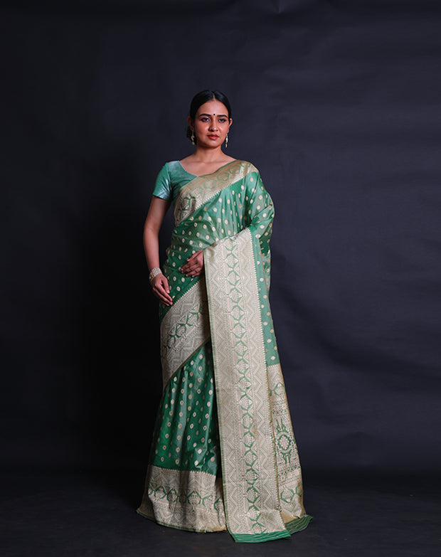 A green blended saree features beige thread buttis scattered elegantly across the drape,- BLN01076