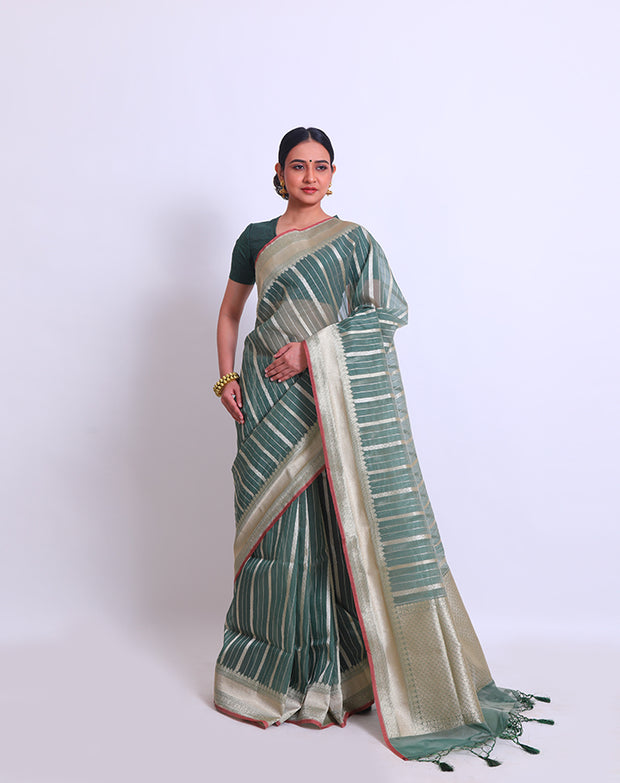 The green semi-organza saree with a zari border and pallu, adorned with green tassels and a pink selvage - FCT011113