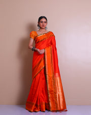 An orange Kanjivaram soft silk saree features elegant self-lines woven throughout the drape, - KSL03001