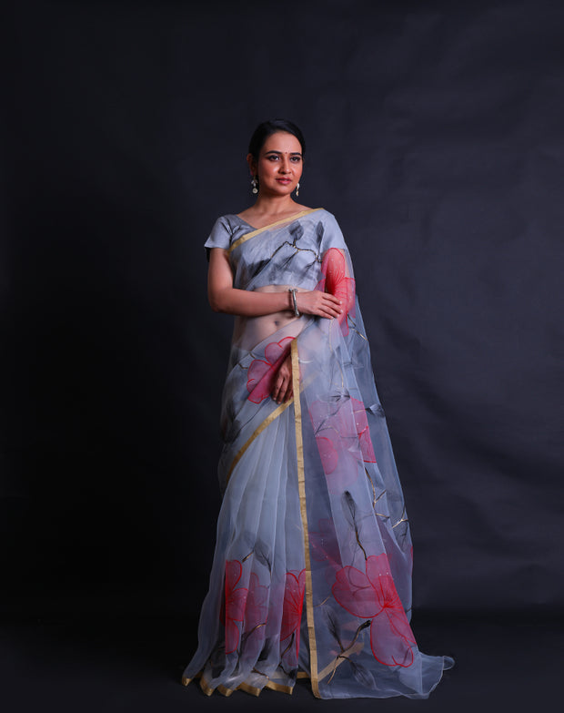 The grey blended organza saree with handprint in a colorful way, along with gold lines hand-printed in a modern attire,- BLN01279