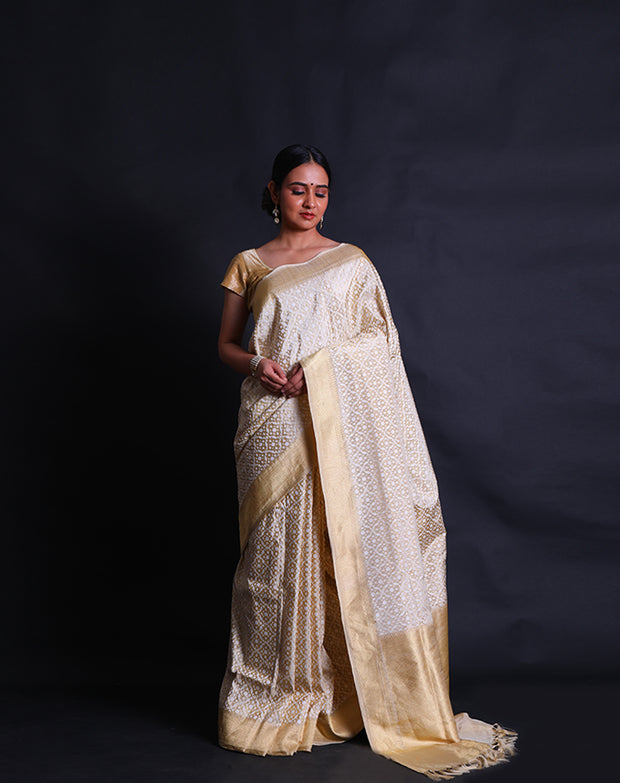 The off-white Banarasi silk cotton saree you've described exudes elegance with its intricate white thread woven design all over the drape - BSK010428