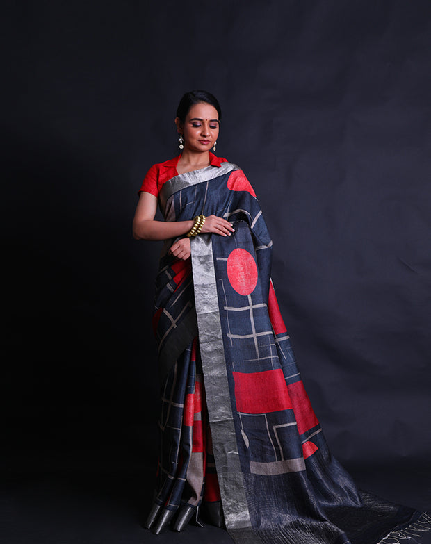 The black Desi Tussar saree featuring a zari border and pallu exudes timeless elegance.- PTS05292
