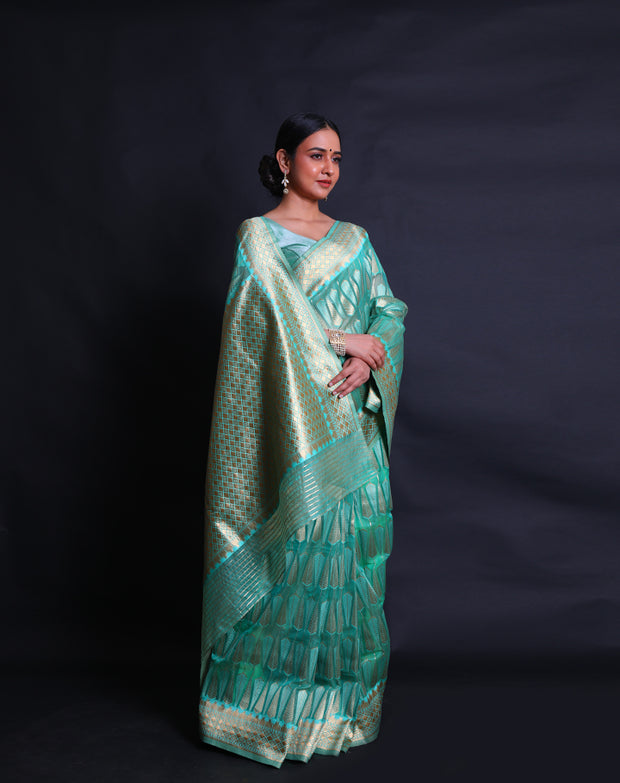 A green blended saree features beige thread buttis scattered elegantly across the drape, - BLN01078