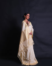 The off-white Banarasi silk cotton saree you've described exudes elegance with its intricate white thread woven design all over the drape - BSK010428