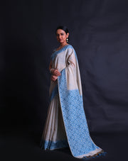 The Beige blended Tussar cotton saree with small buttis of zari and blue thread all over the drape,-  BLN01371