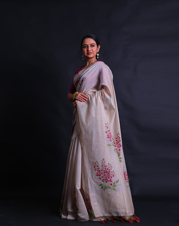 The beige blended Tussar cotton saree adorned with machine-embroidered flower designs in wine, green thread, - BLN01373