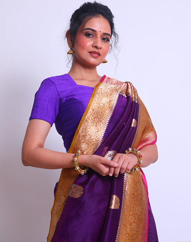 The Purple Organza Handloom saree with a combination of gold border and pink selvage on the border and pallu sounds absolutely elegant - BSK010257