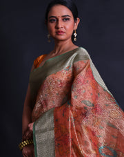 The orange semi-crusted tissue saree adorned with colorful flower designs all over the drape,- FCT011107