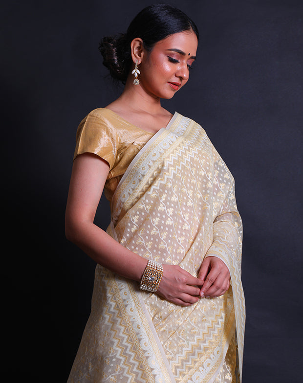 The beige kora cotton saree you described is adorned with white and zari thread woven all over the drape,- BSK010448