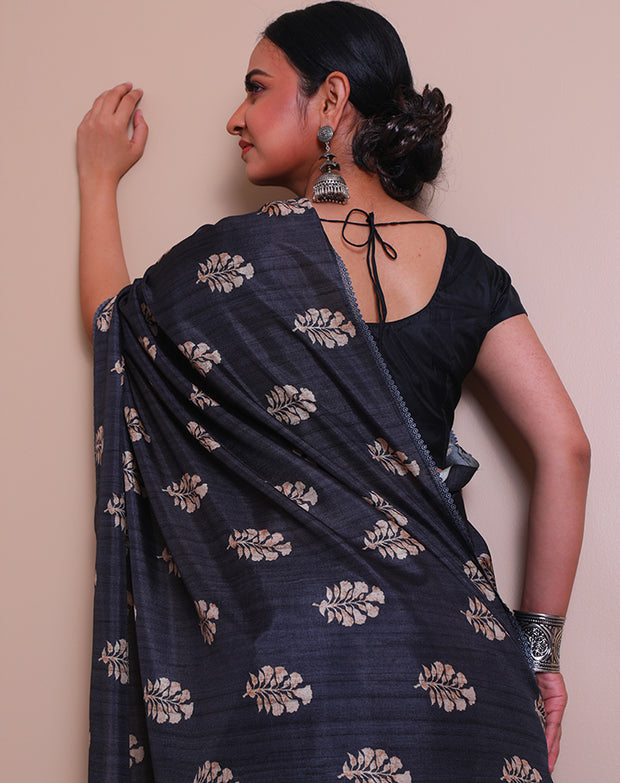 The black blended Tussar saree with a batik-style print of flowers all over the drape sounds elegant and artistic - BLN01378