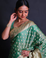 A green blended saree features beige thread buttis scattered elegantly across the drape,- BLN01076