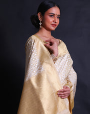 The off-white Banarasi silk cotton saree you've described exudes elegance with its intricate white thread woven design all over the drape - BSK010428