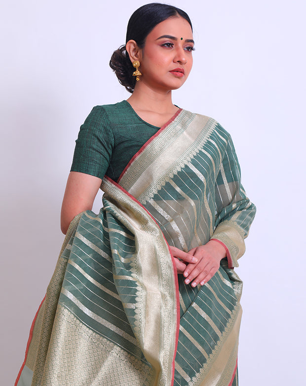 The green semi-organza saree with a zari border and pallu, adorned with green tassels and a pink selvage - FCT011113