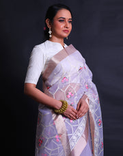 The light mauve organza saree with thread machine embroidery in white and colorful flowers all over the drape,- BLN01555