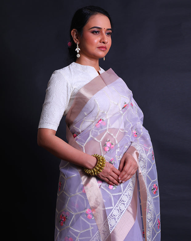 The light mauve organza saree with thread machine embroidery in white and colorful flowers all over the drape,- BLN01555