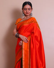 An orange Kanjivaram soft silk saree features elegant self-lines woven throughout the drape, - KSL03001