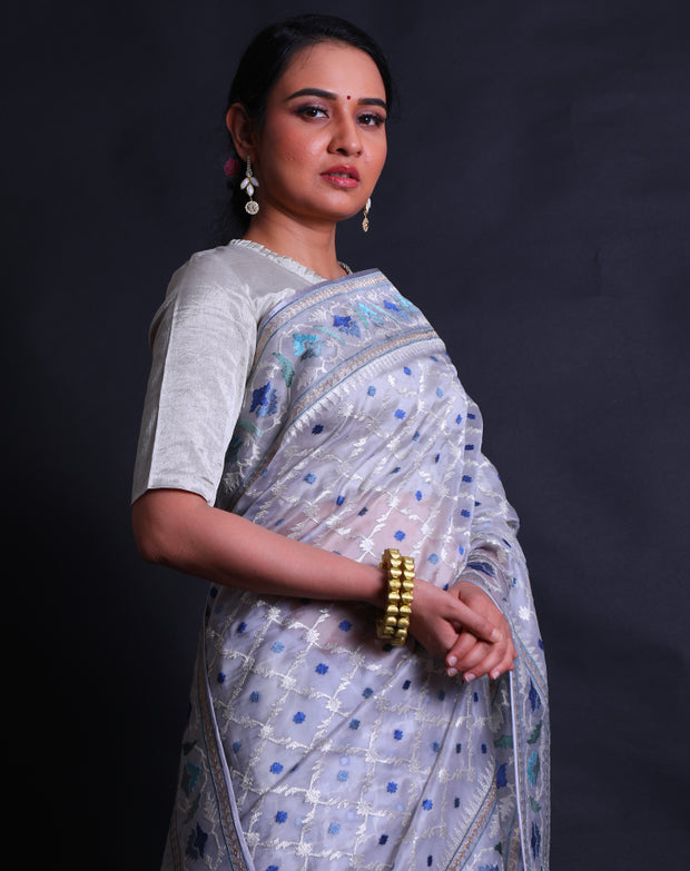 The grey pure organza saree with silver zari and shades of blue thread digitally embroidered all over the drape,- EMB03355