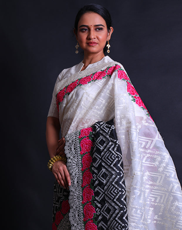The black and white two-color organza saree with thread and zari embroidery featuring colorful rose flower design,- EMB03358