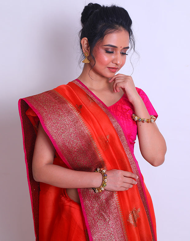 The Orange Organza Handloom saree with a contrast rani color border and pallu featuring antique zari weaving sounds stunning - BSK010449