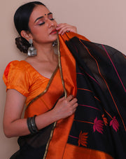 A black Banarasi cotton saree is beautifully adorned with colorful lines and a lotus design woven throughout the drape,- BSK04490