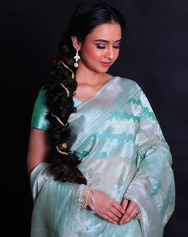 The light green pure kora saree radiates elegance with its intricate silver zari and thread work adorning the entirety of the drape,- BSK010527